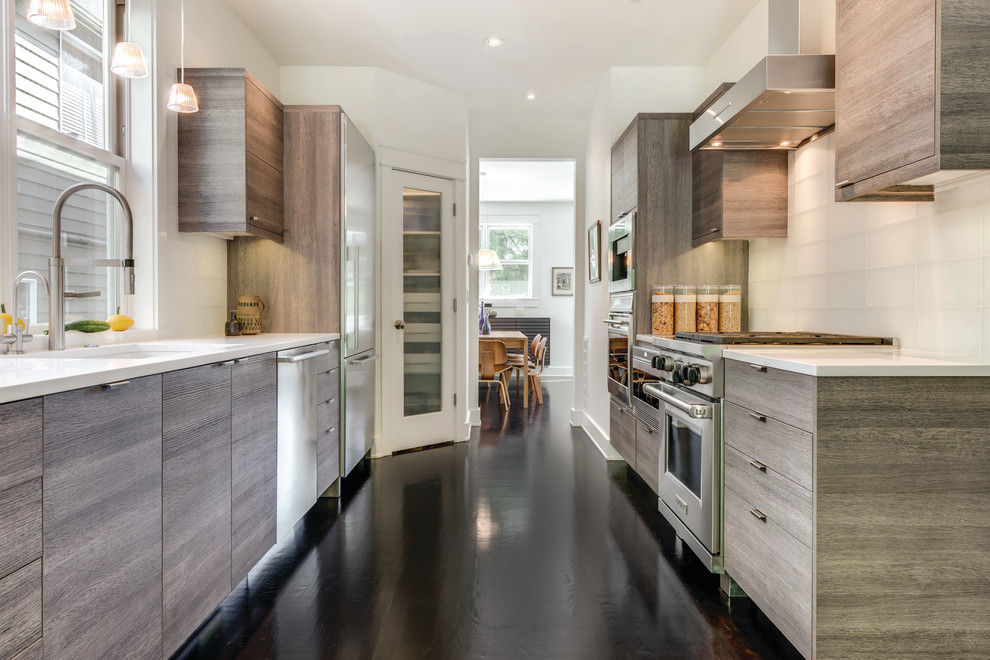 Inspiration for a large contemporary galley dark wood floor eat-in kitchen remodel in Seattle with an undermount sink, flat-panel cabinets, medium tone wood cabinets, quartz countertops, white backsplash, glass tile backsplash, stainless steel appliances and no island