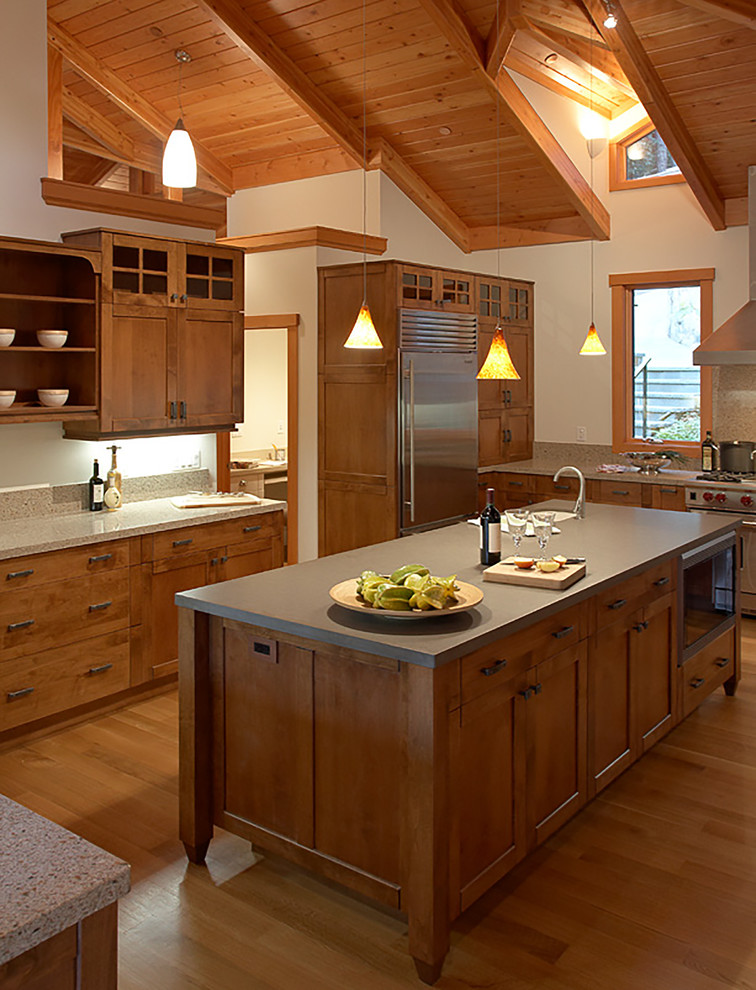 Inspiration for a transitional medium tone wood floor kitchen remodel in Seattle with shaker cabinets, medium tone wood cabinets, an undermount sink, quartz countertops, stainless steel appliances and an island