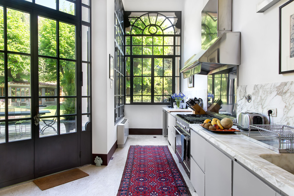 На фото: прямая кухня в современном стиле с плоскими фасадами, серыми фасадами, техникой из нержавеющей стали, белой столешницей, белым фартуком и белым полом с