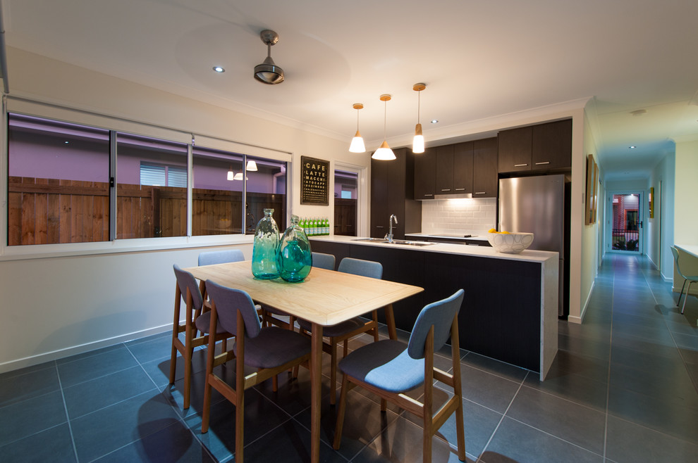 Photo of a contemporary galley kitchen/diner in Sunshine Coast with dark wood cabinets, engineered stone countertops, white splashback, cement tile splashback and stainless steel appliances.