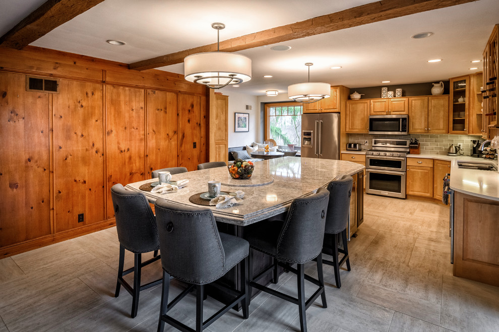 Example of a mid-sized arts and crafts l-shaped porcelain tile and gray floor eat-in kitchen design in Cleveland with a triple-bowl sink, raised-panel cabinets, light wood cabinets, quartz countertops, gray backsplash, subway tile backsplash, stainless steel appliances and an island