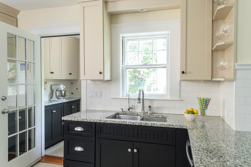 Mid-sized arts and crafts u-shaped linoleum floor enclosed kitchen photo in Boston with a double-bowl sink, recessed-panel cabinets, beige cabinets, granite countertops, white backsplash, subway tile backsplash, stainless steel appliances and a peninsula