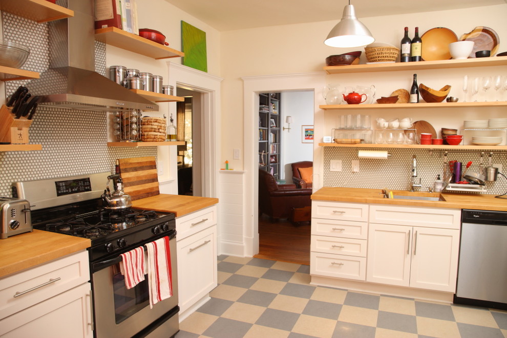 Idéer för att renovera ett avskilt, litet funkis l-kök, med en enkel diskho, släta luckor, vita skåp, träbänkskiva, stänkskydd i keramik, rostfria vitvaror och linoleumgolv