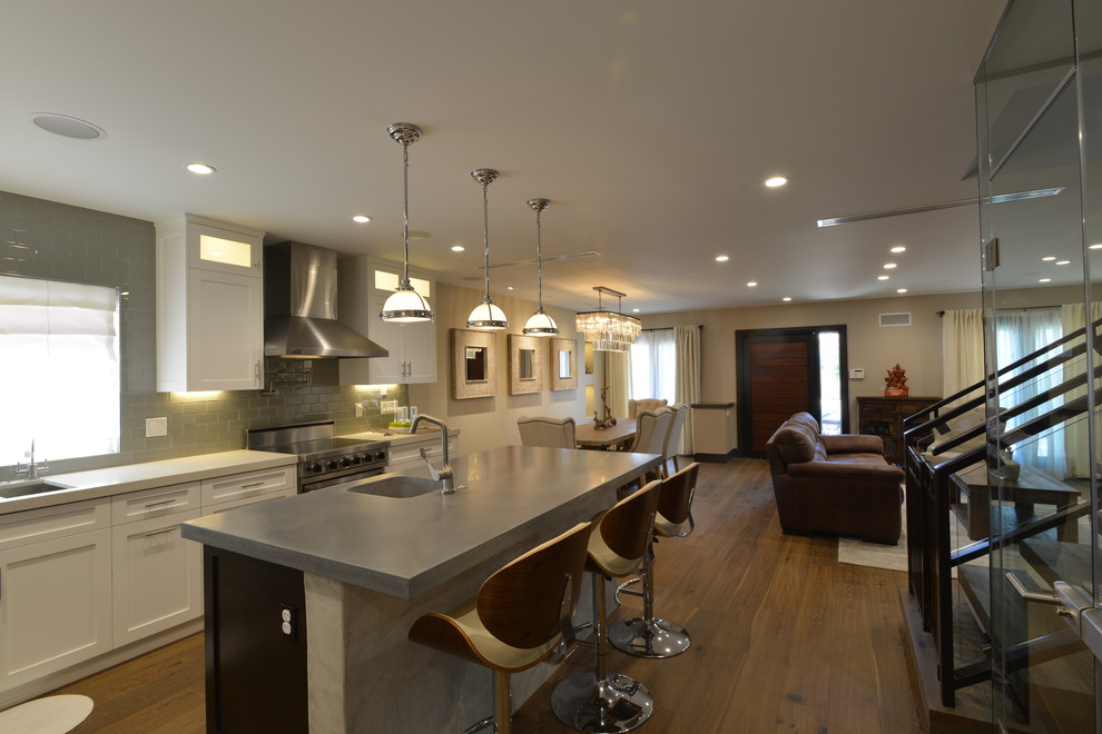 Foto på ett stort funkis kök, med en integrerad diskho, skåp i shakerstil, vita skåp, bänkskiva i zink, grått stänkskydd, stänkskydd i tunnelbanekakel, rostfria vitvaror, mellanmörkt trägolv och en köksö