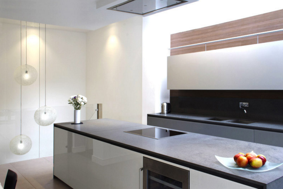 Modern inredning av ett stort grå linjärt grått kök och matrum, med en dubbel diskho, luckor med glaspanel, grå skåp, grått stänkskydd, stänkskydd i trä, rostfria vitvaror, klinkergolv i porslin, en köksö och grått golv