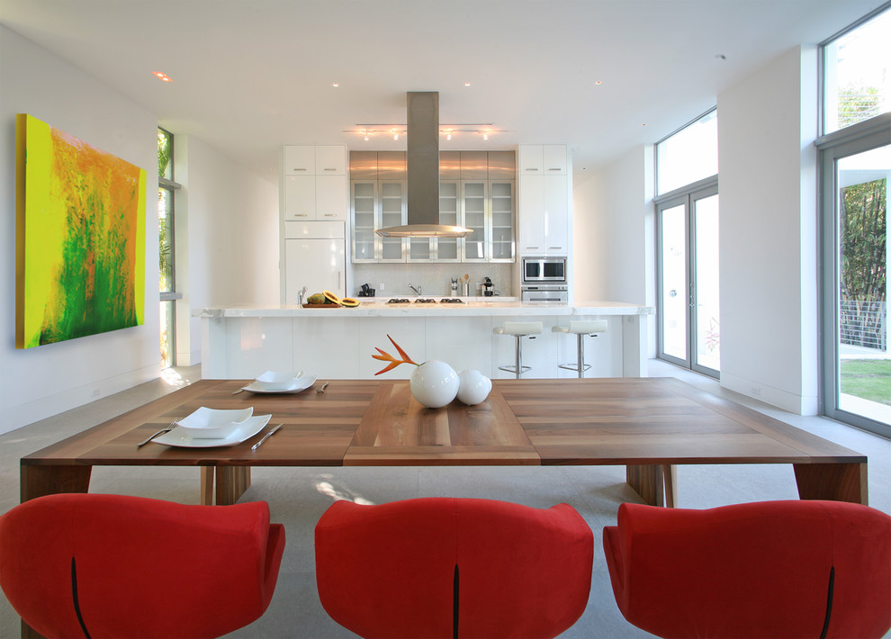 Moderne Küche mit Glasfronten, weißen Schränken und Elektrogeräten mit Frontblende in Miami