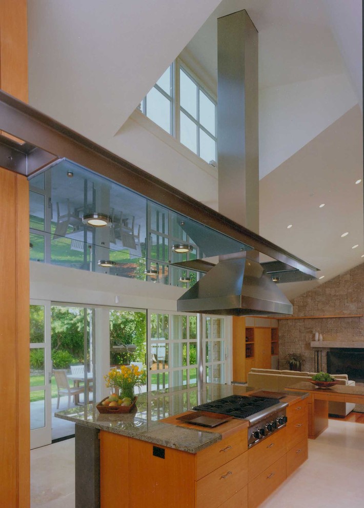 Foto på ett stort funkis kök, med en undermonterad diskho, släta luckor, skåp i ljust trä, granitbänkskiva, grått stänkskydd, stänkskydd i sten, rostfria vitvaror, kalkstensgolv och en köksö
