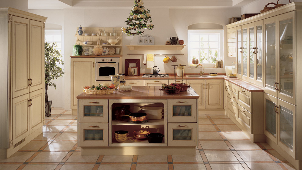 Idéer för mellanstora rustika kök, med en undermonterad diskho, luckor med upphöjd panel, skåp i slitet trä, kaklad bänkskiva, klinkergolv i keramik, en köksö och beiget golv