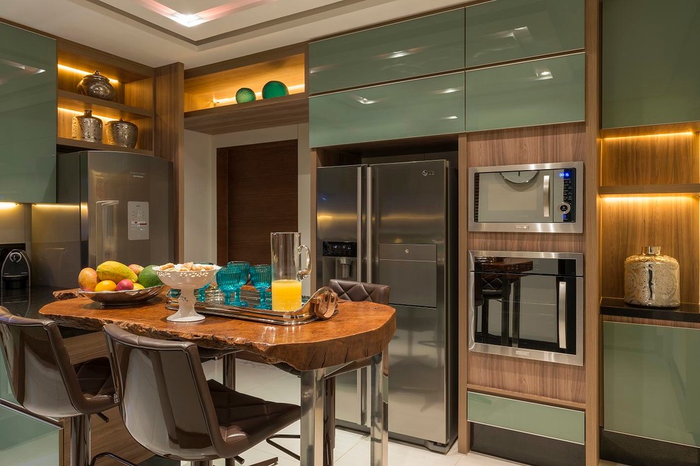 Diseño de cocina contemporánea con armarios con paneles lisos, puertas de armario verdes, electrodomésticos de acero inoxidable y una isla