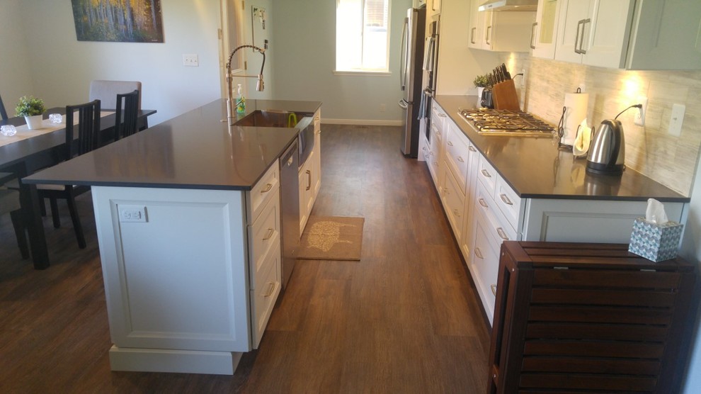Mid-sized transitional galley vinyl floor and gray floor eat-in kitchen photo in Salt Lake City with a farmhouse sink, recessed-panel cabinets, white cabinets, quartz countertops, beige backsplash, limestone backsplash, stainless steel appliances and an island