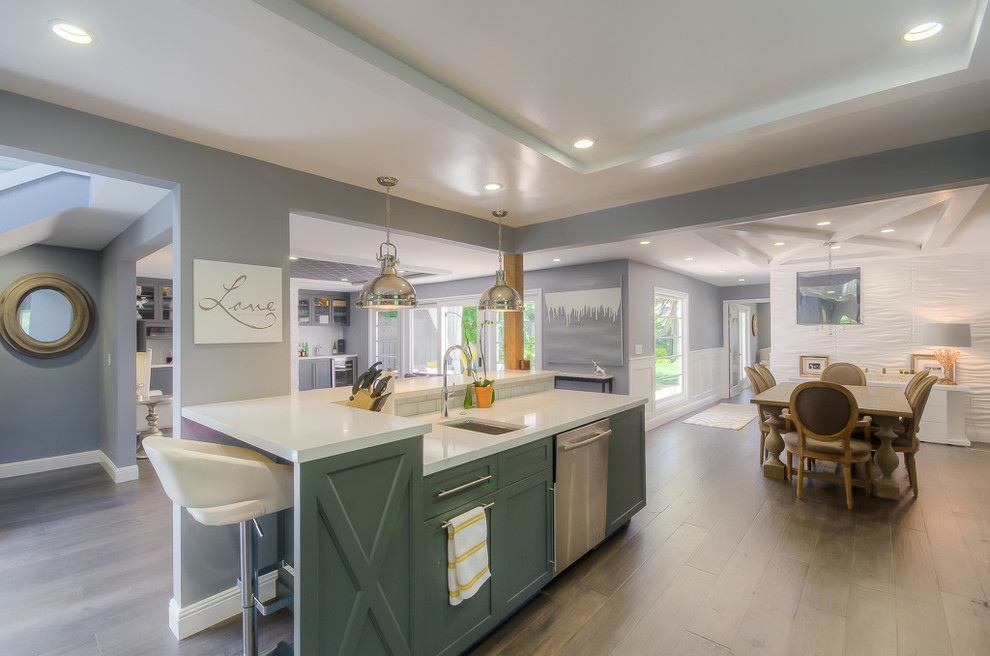 This is an example of a medium sized traditional single-wall kitchen/diner in Los Angeles with a submerged sink, shaker cabinets, grey cabinets, white splashback, metro tiled splashback, stainless steel appliances, medium hardwood flooring and no island.