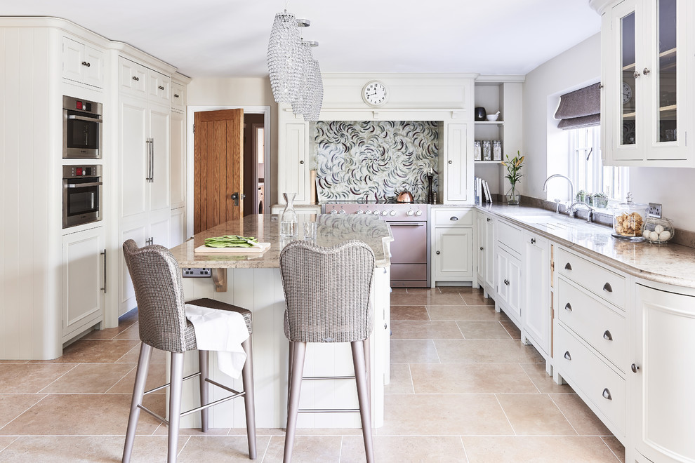This is an example of a classic enclosed kitchen in Wiltshire with a submerged sink, white cabinets, multi-coloured splashback, coloured appliances, an island, beige floors and beige worktops.
