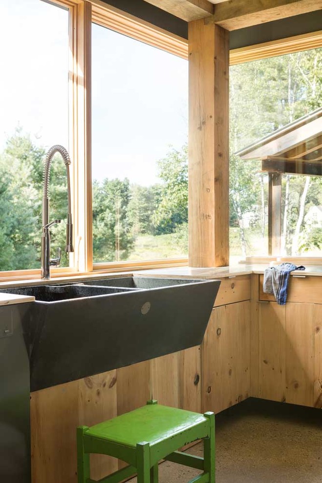 Exemple d'une cuisine linéaire nature en bois clair de taille moyenne avec un évier de ferme et un placard à porte plane.
