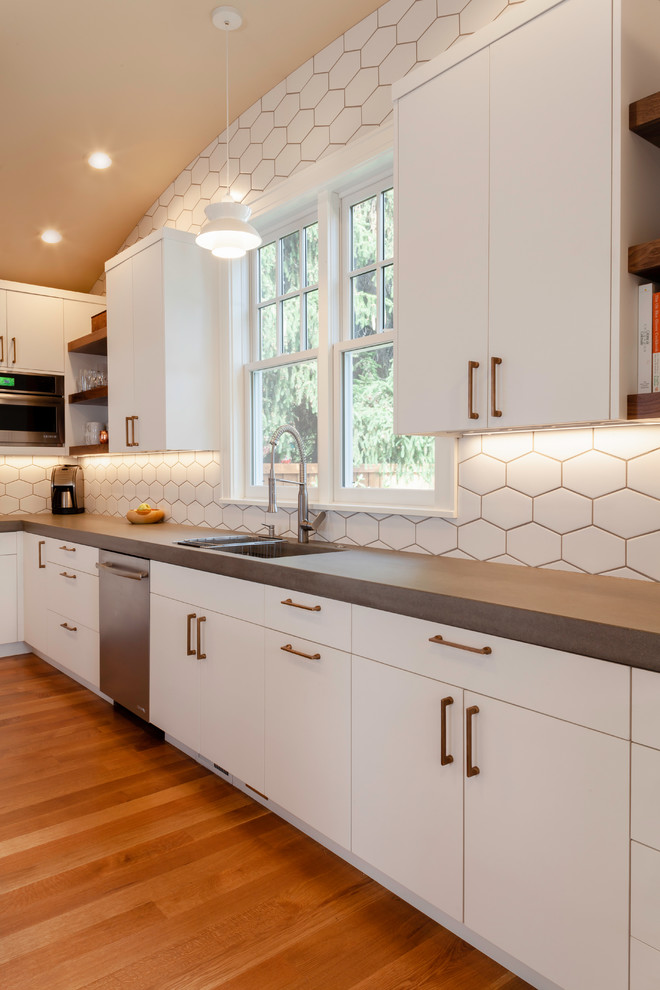 Eat-in kitchen - mid-sized scandinavian l-shaped medium tone wood floor and brown floor eat-in kitchen idea in Other with an undermount sink, flat-panel cabinets, white cabinets, concrete countertops, white backsplash, ceramic backsplash, paneled appliances, an island and gray countertops