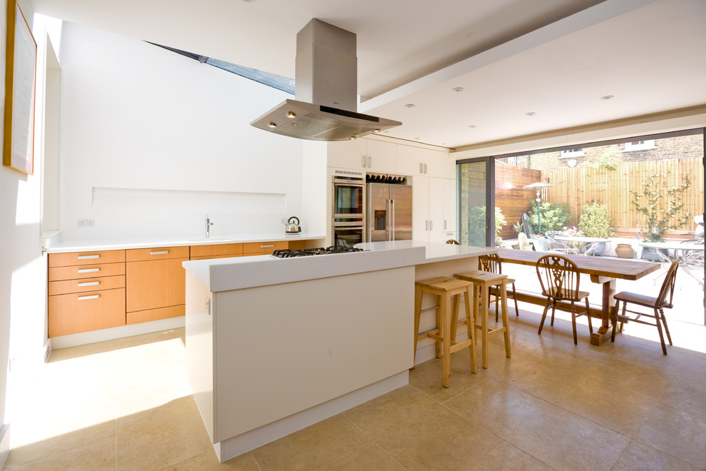 Foto di una cucina minimal di medie dimensioni con lavello sottopiano, ante lisce, ante in legno chiaro, top in quarzite, elettrodomestici in acciaio inossidabile, pavimento beige e top bianco