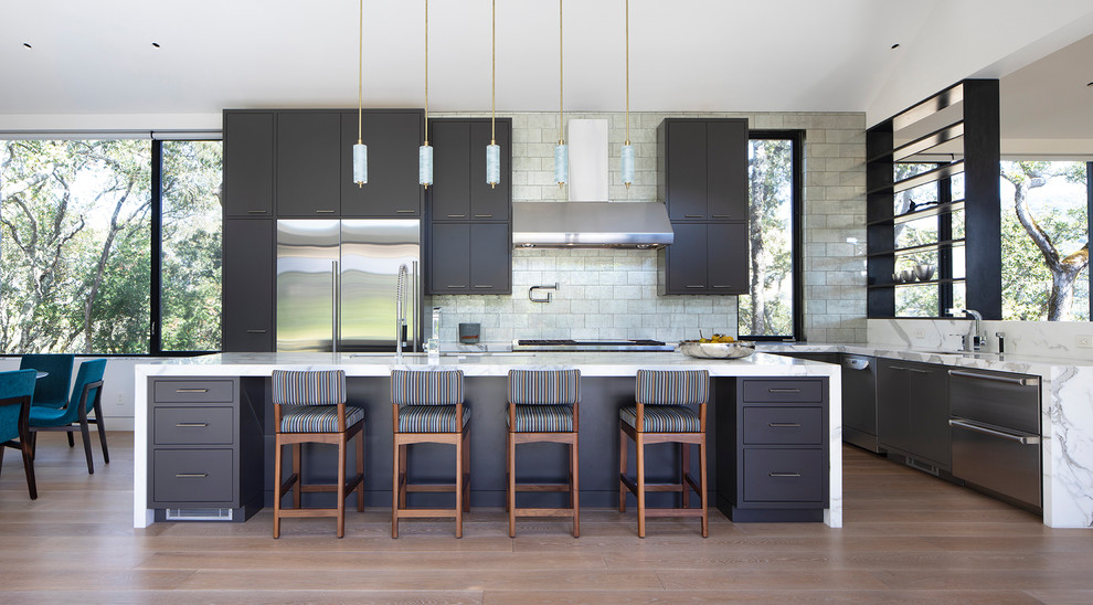 Photo of a rural l-shaped kitchen in San Francisco with a submerged sink, flat-panel cabinets, grey cabinets, beige splashback, stainless steel appliances, medium hardwood flooring, an island, brown floors and white worktops.