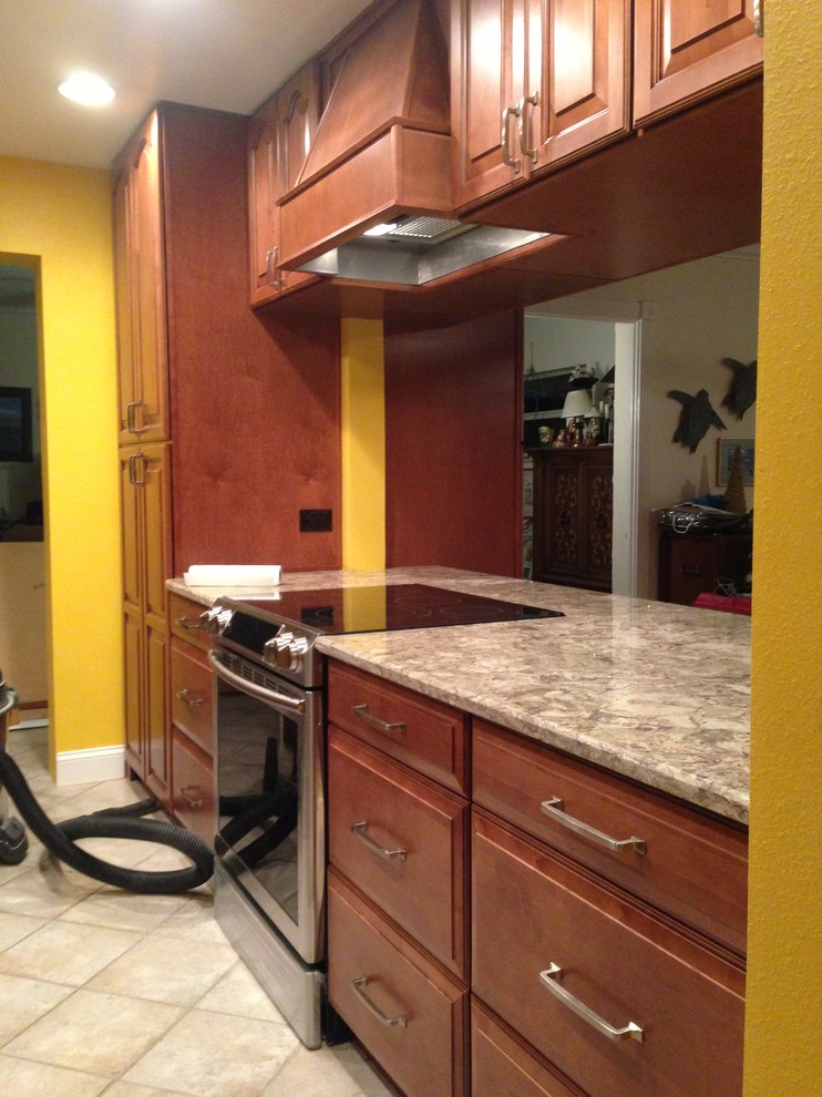 Example of a large classic galley eat-in kitchen design in Orlando with a farmhouse sink, raised-panel cabinets, brown cabinets, granite countertops and stainless steel appliances