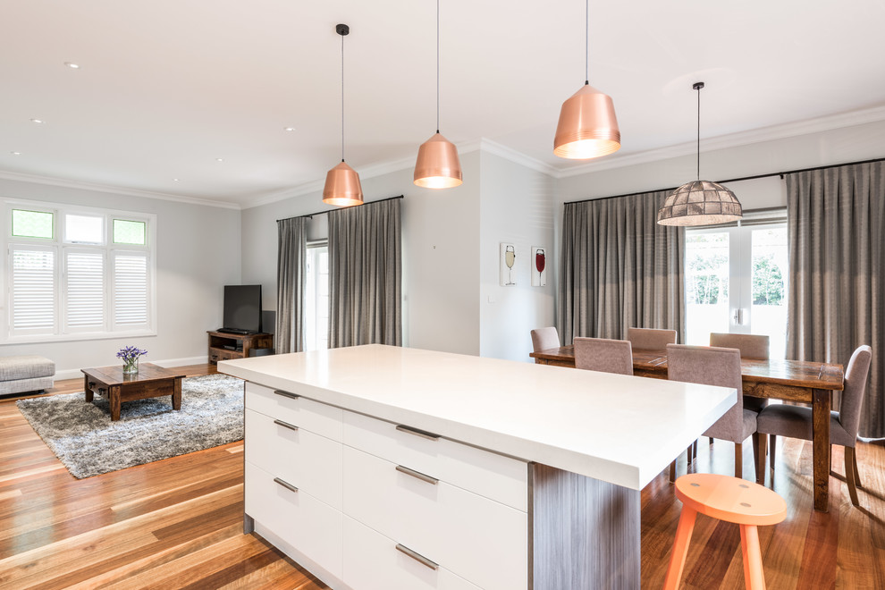 Inspiration for a mid-sized contemporary l-shaped medium tone wood floor eat-in kitchen remodel in Melbourne with a drop-in sink, flat-panel cabinets, dark wood cabinets, quartz countertops, gray backsplash, glass sheet backsplash, stainless steel appliances and an island