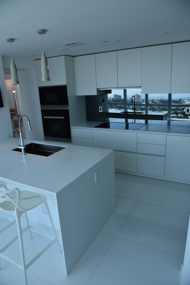 Exempel på ett mellanstort modernt vit vitt kök, med en nedsänkt diskho, släta luckor, vita skåp, bänkskiva i kvarts, vitt stänkskydd, glaspanel som stänkskydd, rostfria vitvaror, klinkergolv i porslin, en köksö och vitt golv