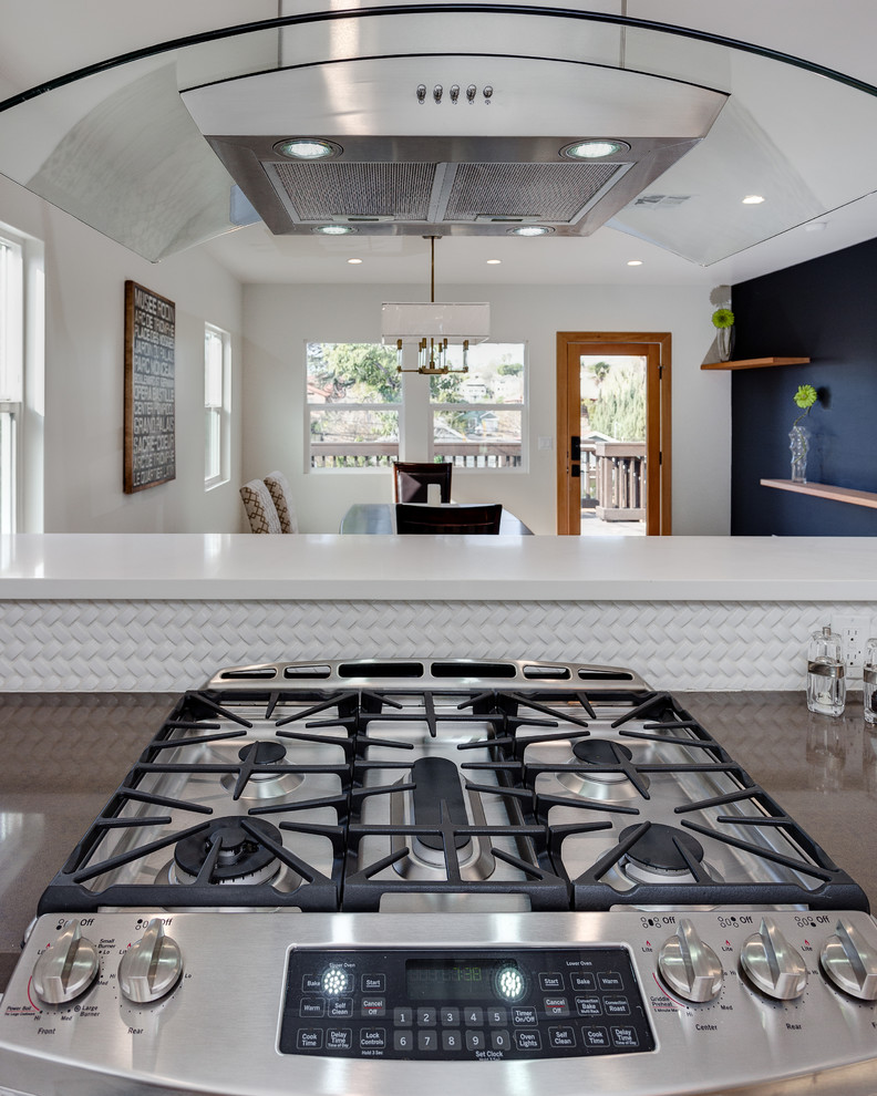 Exempel på ett mellanstort modernt kök, med en dubbel diskho, luckor med infälld panel, vita skåp, granitbänkskiva, vitt stänkskydd, stänkskydd i keramik, rostfria vitvaror, ljust trägolv och en köksö