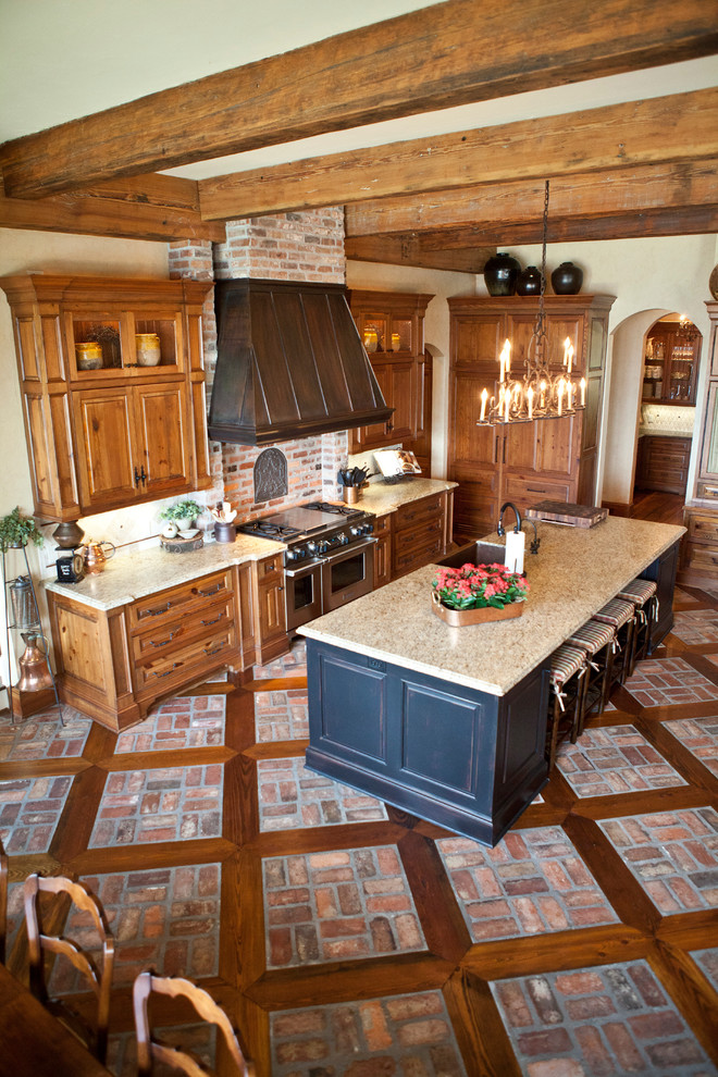 Idéer för att renovera ett stort vintage kök, med en nedsänkt diskho, luckor med infälld panel, skåp i mellenmörkt trä, granitbänkskiva, beige stänkskydd, stänkskydd i tunnelbanekakel, rostfria vitvaror, tegelgolv och en köksö