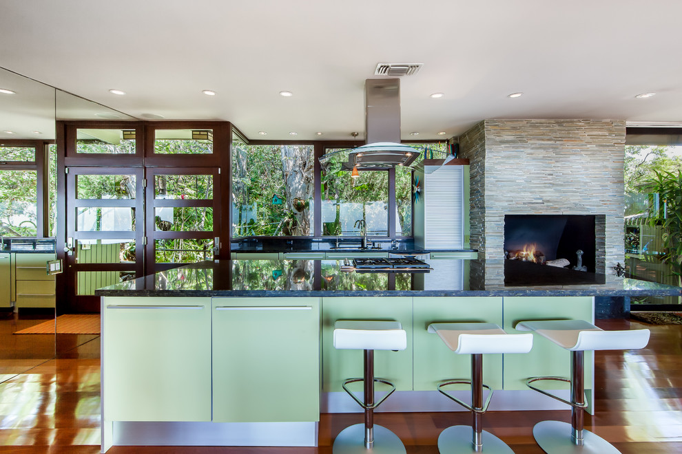 ロサンゼルスにあるミッドセンチュリースタイルのおしゃれなアイランドキッチン (フラットパネル扉のキャビネット、緑のキャビネット) の写真