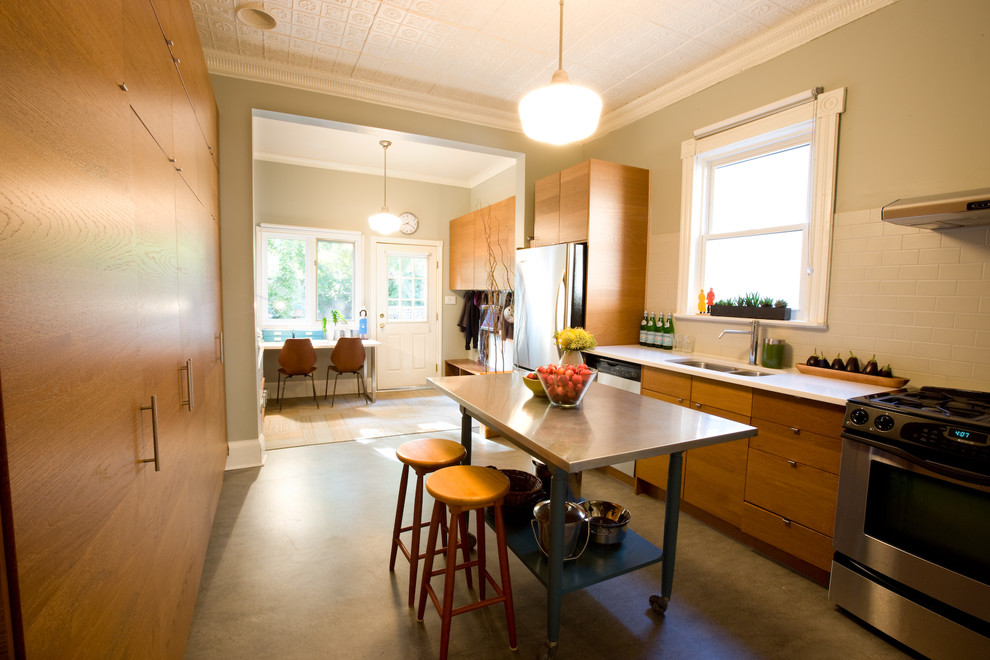 Einzeilige Moderne Küche mit Doppelwaschbecken, flächenbündigen Schrankfronten, hellbraunen Holzschränken, Küchenrückwand in Weiß, Rückwand aus Metrofliesen und Küchengeräten aus Edelstahl in Toronto