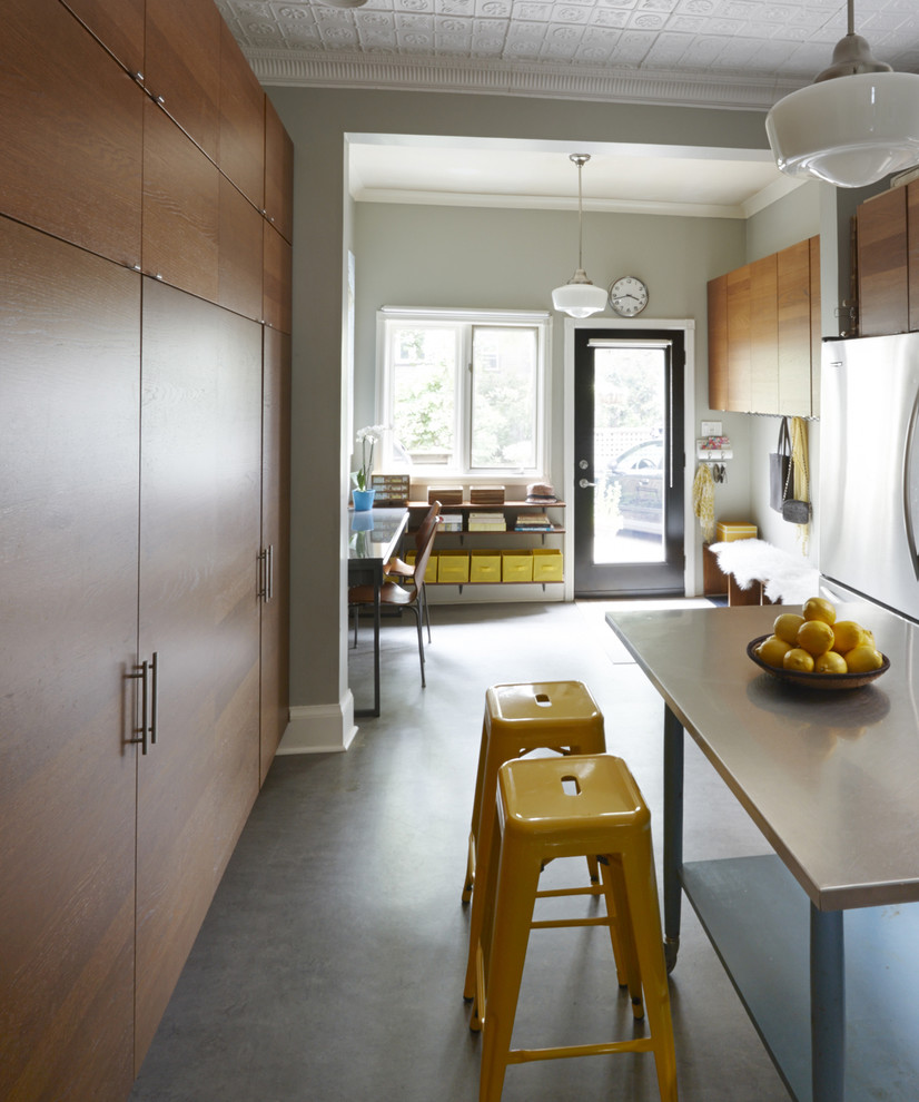 Geschlossene, Mittelgroße Moderne Küche mit flächenbündigen Schrankfronten, hellbraunen Holzschränken, Edelstahl-Arbeitsplatte, Linoleum und Kücheninsel in Toronto