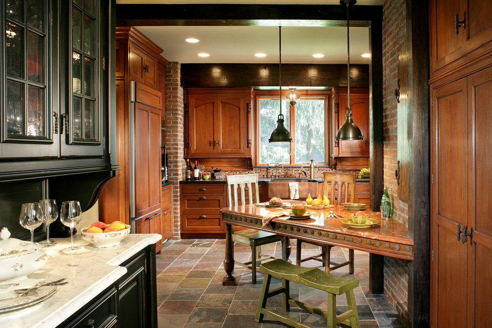 Inredning av ett lantligt stort kök, med en rustik diskho, luckor med infälld panel, bruna skåp, granitbänkskiva, flerfärgad stänkskydd, stänkskydd i mosaik, rostfria vitvaror och skiffergolv