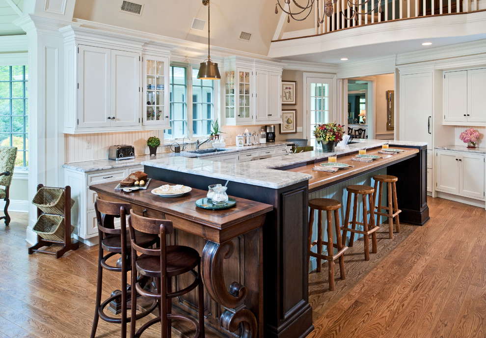 Example of a large classic galley medium tone wood floor open concept kitchen design in New York with an undermount sink, recessed-panel cabinets, white cabinets, quartzite countertops, white backsplash, wood backsplash, stainless steel appliances and an island