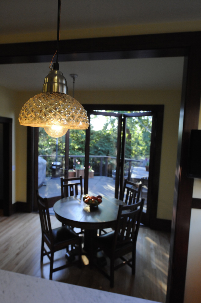Cette image montre une grande salle à manger ouverte sur la cuisine traditionnelle avec un sol en bois brun et un sol marron.