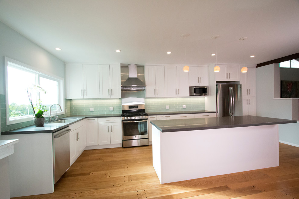 Large trendy l-shaped medium tone wood floor and brown floor open concept kitchen photo in San Francisco with a single-bowl sink, shaker cabinets, white cabinets, quartz countertops, green backsplash, glass tile backsplash, stainless steel appliances and an island