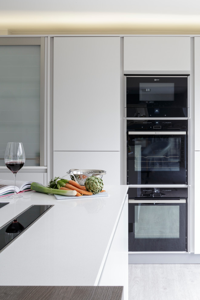 Exempel på ett modernt kök och matrum, med grå skåp, bänkskiva i kvartsit, blått stänkskydd, glaspanel som stänkskydd och en köksö