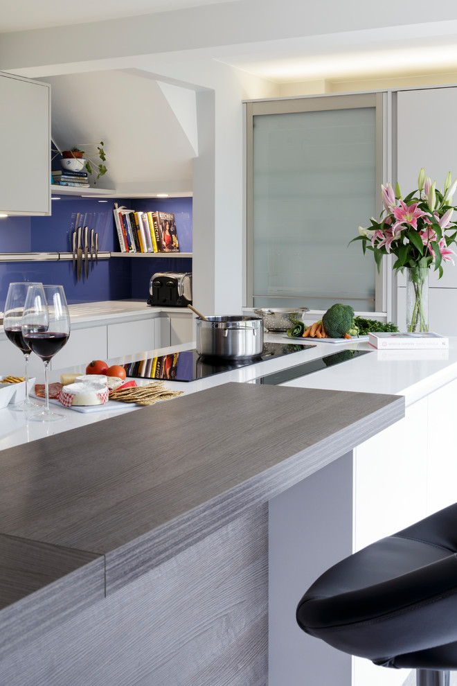 Inspiration for a contemporary kitchen/diner in Berkshire with grey cabinets, quartz worktops, blue splashback, glass sheet splashback and an island.