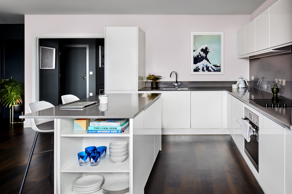 Modern inredning av ett mellanstort grå grått kök, med en undermonterad diskho, släta luckor, vita skåp, bänkskiva i koppar, grått stänkskydd, rostfria vitvaror, mörkt trägolv, en köksö och brunt golv