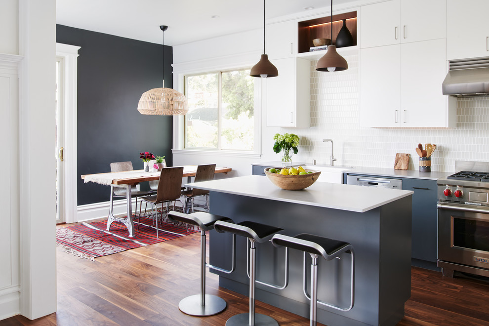 Idéer för att renovera ett mellanstort funkis grå grått kök, med en rustik diskho, släta luckor, grå skåp, bänkskiva i kvarts, stänkskydd i keramik, rostfria vitvaror, mellanmörkt trägolv, en köksö och brunt golv