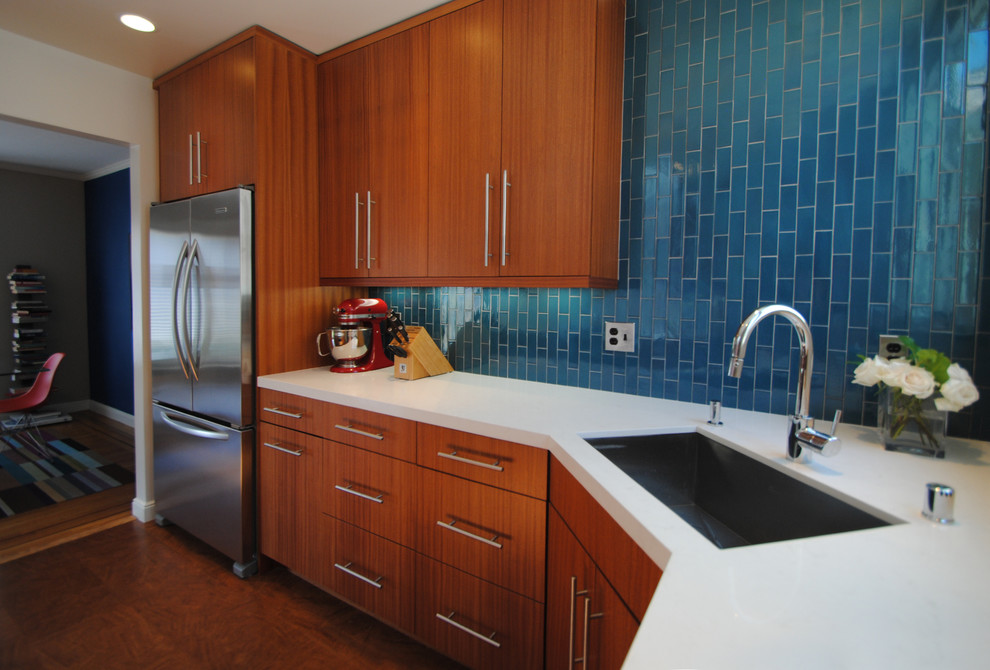 Example of a mid-sized trendy u-shaped medium tone wood floor eat-in kitchen design in San Francisco with an undermount sink, flat-panel cabinets, medium tone wood cabinets, quartz countertops, blue backsplash, ceramic backsplash, stainless steel appliances and no island