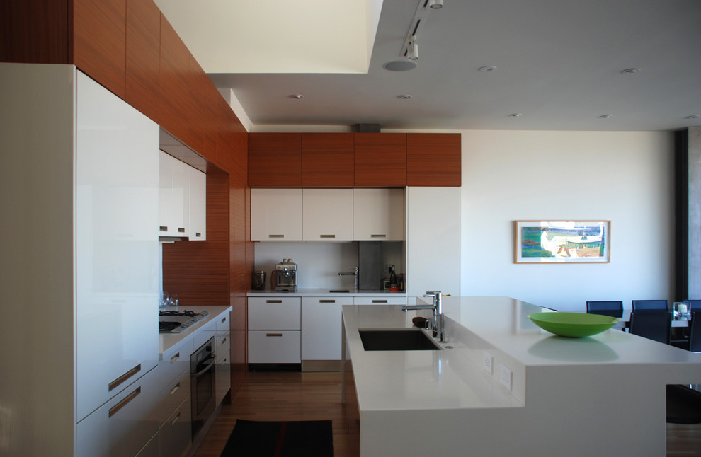 Ejemplo de cocina minimalista abierta con fregadero bajoencimera, armarios con paneles lisos, puertas de armario blancas y encimera de cuarzo compacto