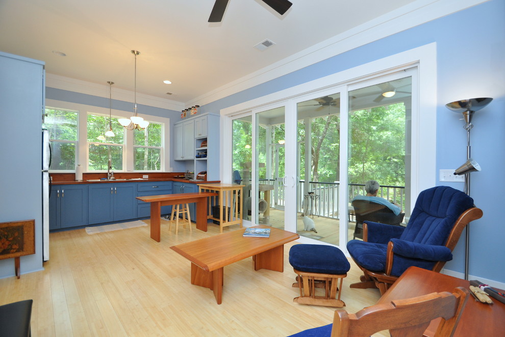 На фото: маленькая п-образная кухня-гостиная с накладной мойкой, плоскими фасадами, синими фасадами, деревянной столешницей и полом из бамбука для на участке и в саду с