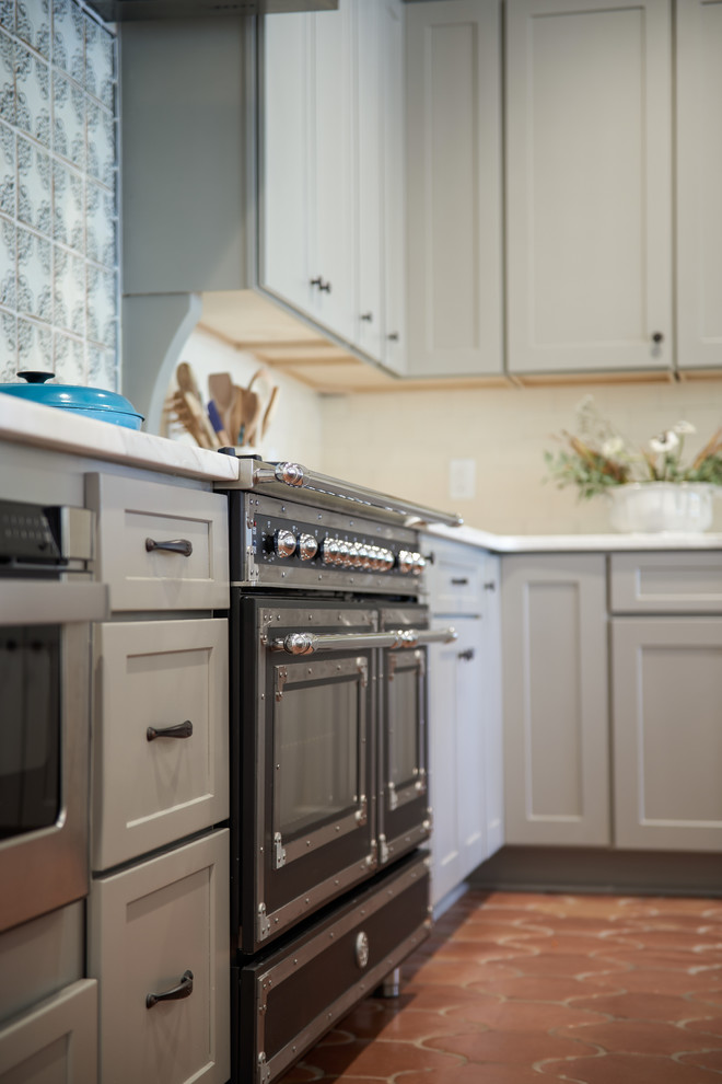 Offene Mediterrane Küche mit Schrankfronten im Shaker-Stil, grauen Schränken, Küchenrückwand in Weiß, schwarzen Elektrogeräten, Terrakottaboden und Kücheninsel in Nashville