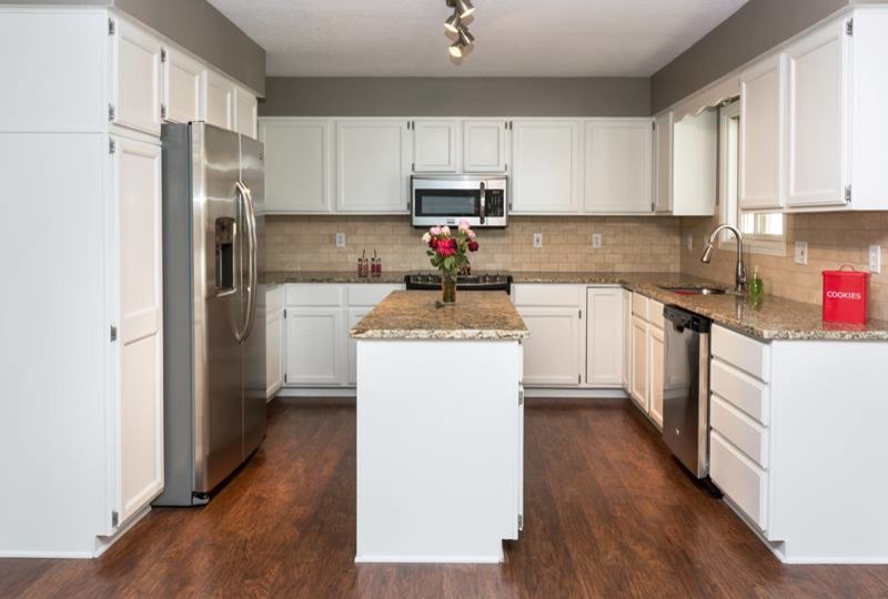 Inspiration for a large modern u-shaped dark wood floor eat-in kitchen remodel in Other with a drop-in sink, shaker cabinets, yellow cabinets, granite countertops, beige backsplash, stone tile backsplash, stainless steel appliances and an island