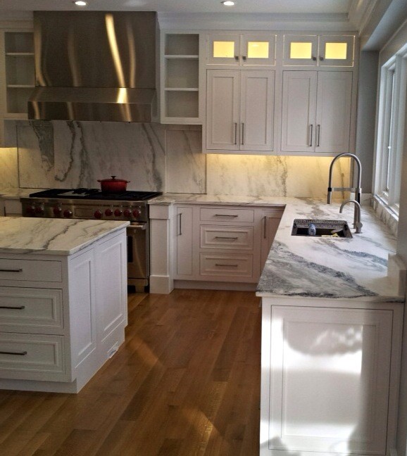 Exempel på ett stort klassiskt kök, med en nedsänkt diskho, luckor med upphöjd panel, vita skåp, marmorbänkskiva, grått stänkskydd, stänkskydd i keramik, rostfria vitvaror, mellanmörkt trägolv och en köksö