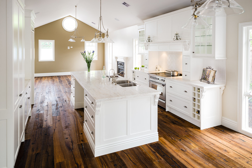 Inspiration for a mid-sized timeless galley dark wood floor open concept kitchen remodel in Melbourne with white cabinets, white backsplash, stainless steel appliances, an island, a double-bowl sink, beaded inset cabinets, marble countertops and ceramic backsplash