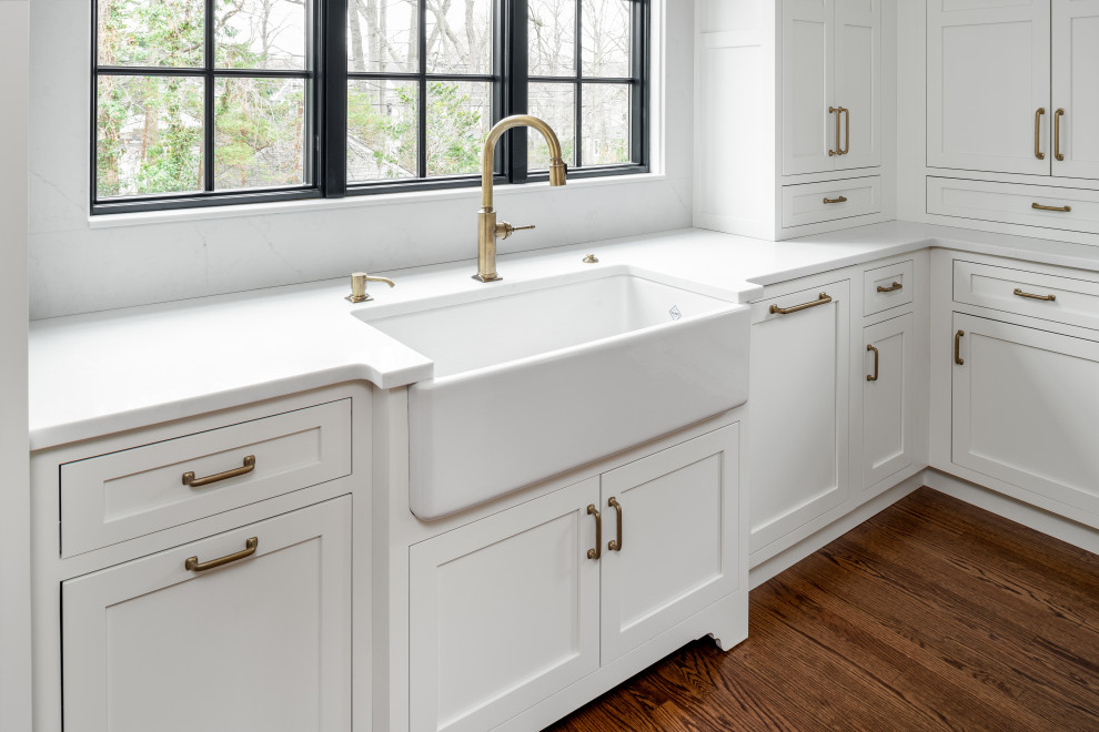Inspiration for a huge transitional l-shaped medium tone wood floor and brown floor eat-in kitchen remodel in New York with a farmhouse sink, beaded inset cabinets, white cabinets, quartz countertops, white backsplash, quartz backsplash, paneled appliances, an island and white countertops