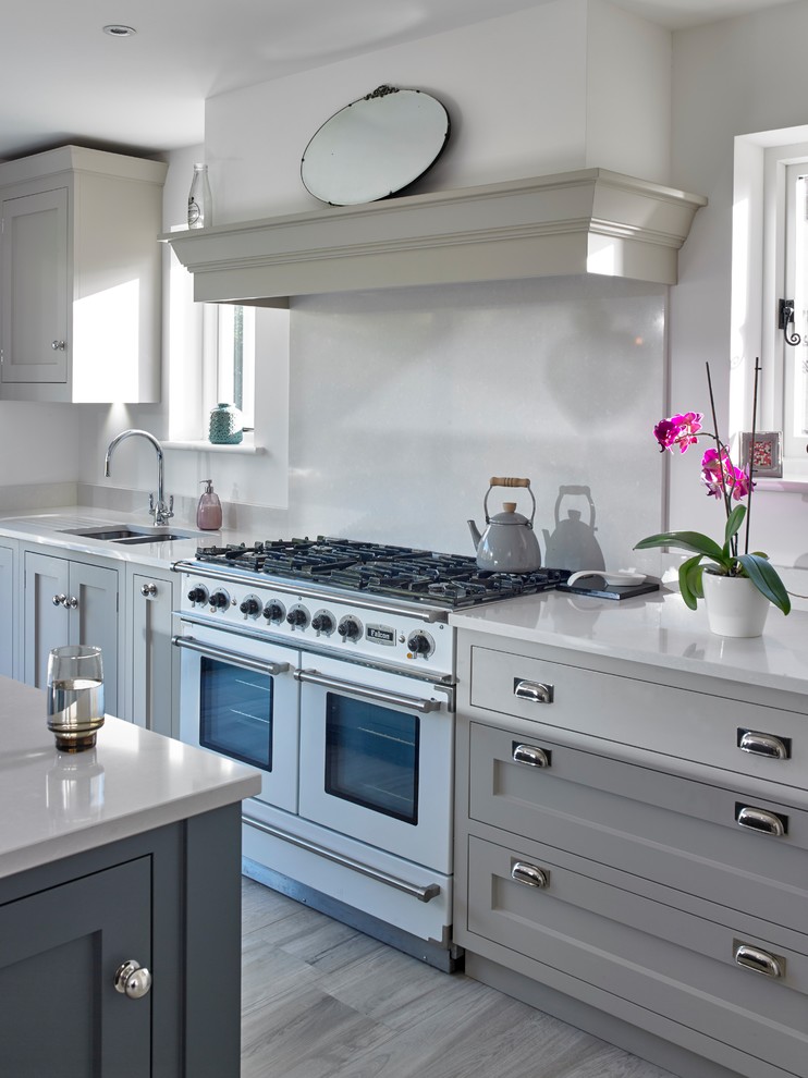 Photo of a medium sized traditional single-wall kitchen/diner in Other with quartz worktops, an island, a submerged sink, shaker cabinets, grey cabinets, white splashback, stainless steel appliances, porcelain flooring, grey floors and white worktops.