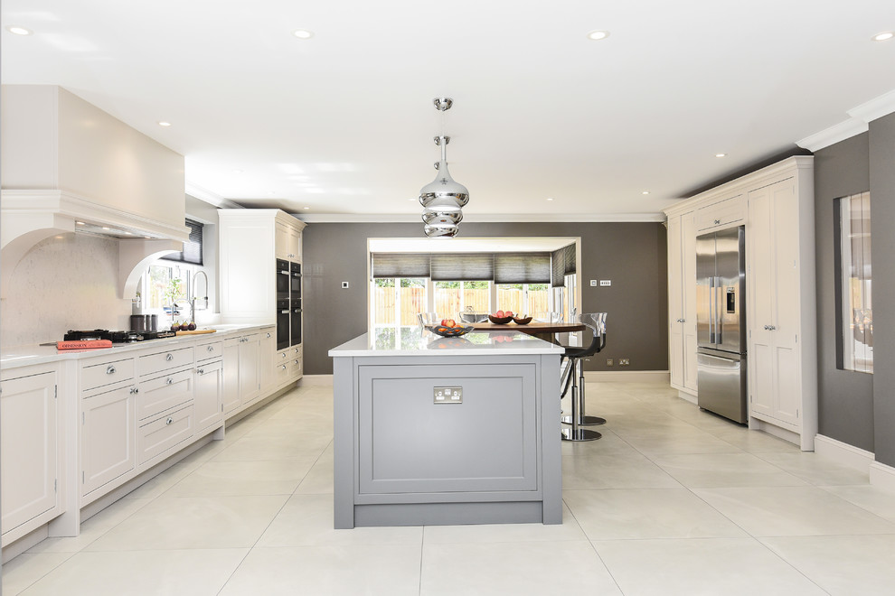 Inspiration for a large traditional galley open plan kitchen in Berkshire with a built-in sink, shaker cabinets, grey cabinets, quartz worktops, white splashback, stone slab splashback, integrated appliances, an island and white worktops.