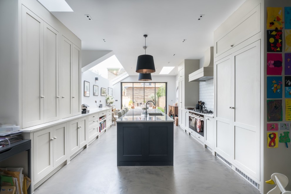 Cette photo montre une grande cuisine ouverte parallèle chic avec un évier posé, un placard à porte shaker, des portes de placard grises, un plan de travail en surface solide, un électroménager en acier inoxydable, sol en béton ciré, îlot, un sol gris et un plan de travail blanc.