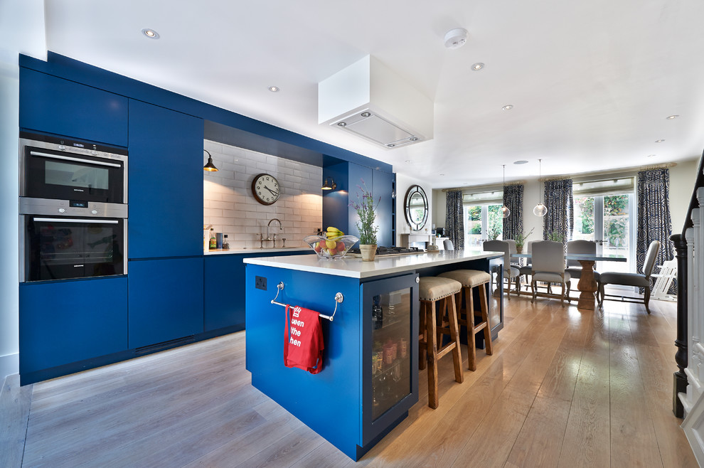 Zweizeilige, Mittelgroße Moderne Küche mit Quarzwerkstein-Arbeitsplatte und Kücheninsel in Surrey