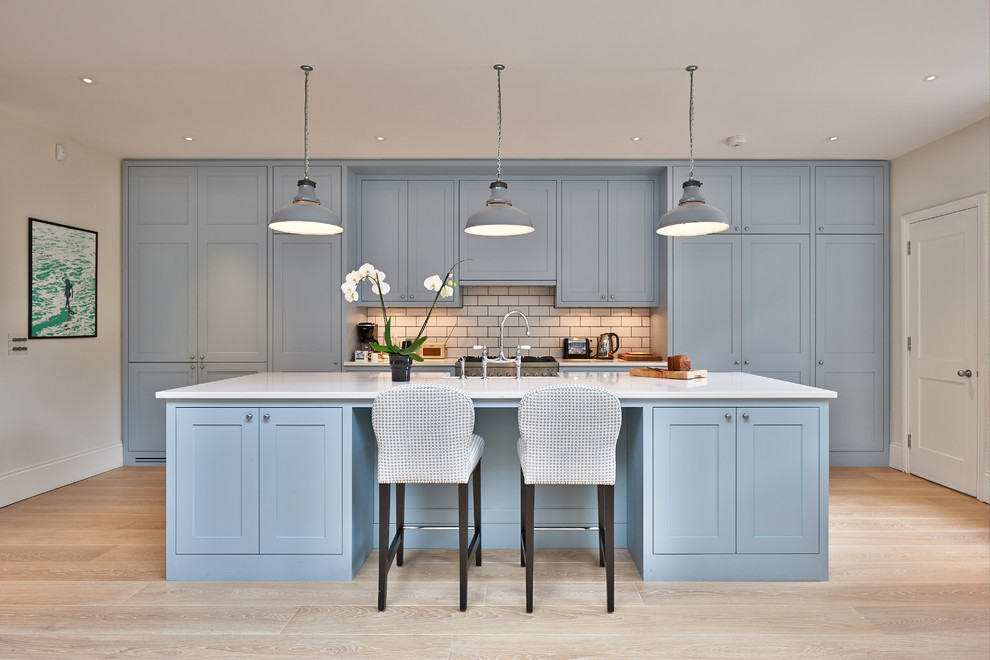 Mid-sized trendy galley kitchen photo in Surrey with quartz countertops and an island