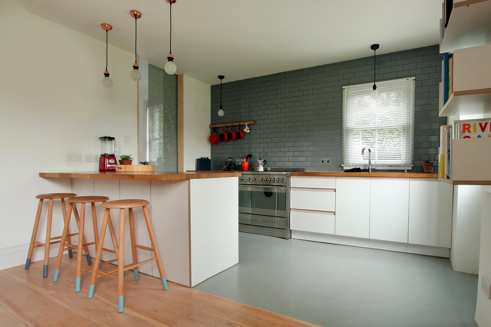 Idéer för mellanstora funkis kök med öppen planlösning, med släta luckor, vita skåp, träbänkskiva, grått stänkskydd, stänkskydd i keramik, rostfria vitvaror och en köksö